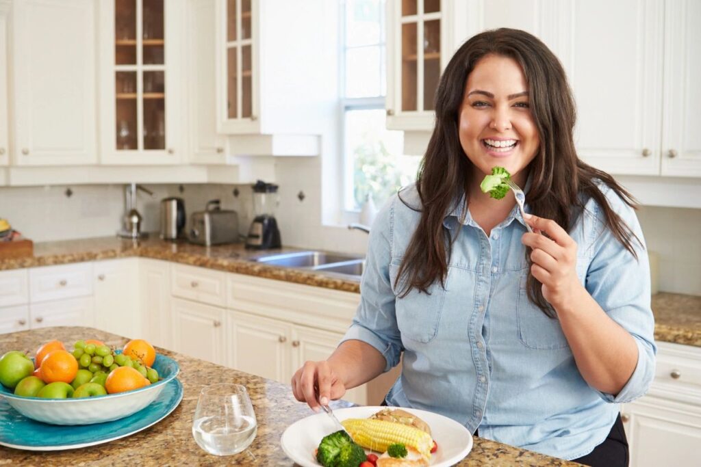 Woman eating a healthy meal in a kitchen