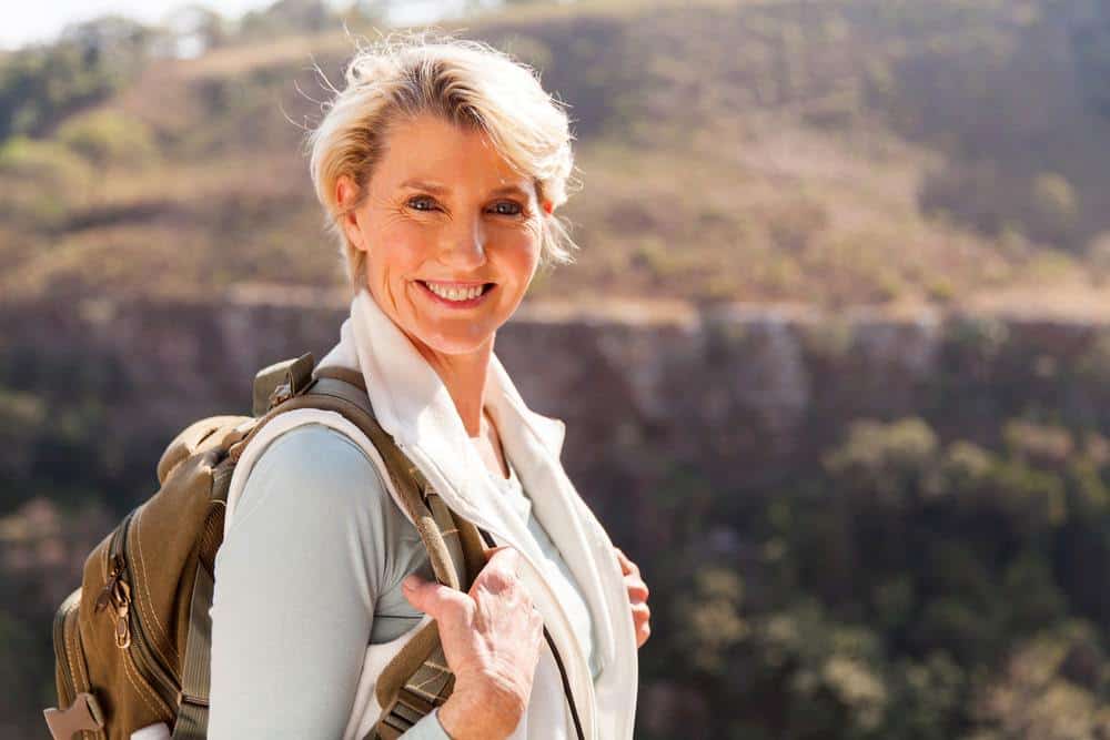 Happy woman with backpack in nature