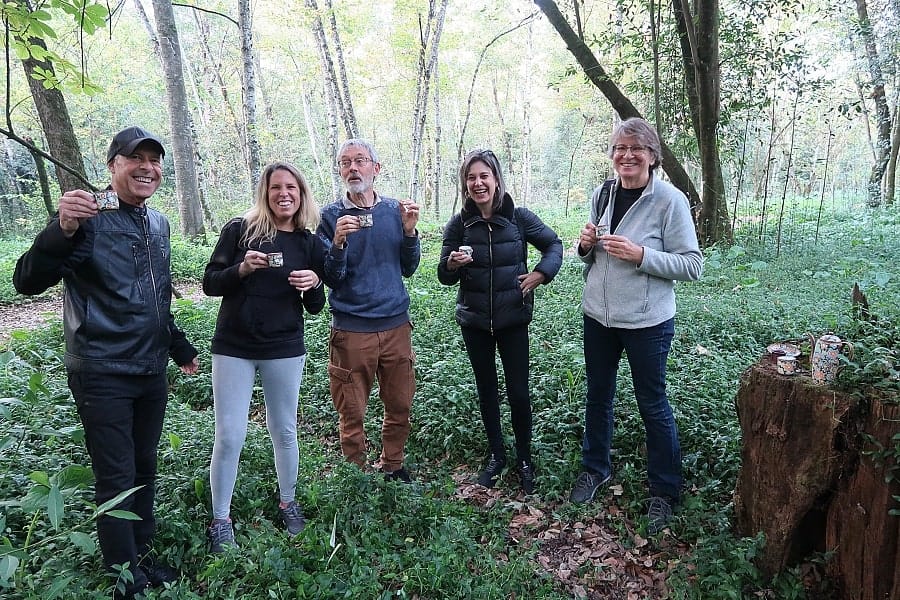 Group of people with cups of tea in a forest
